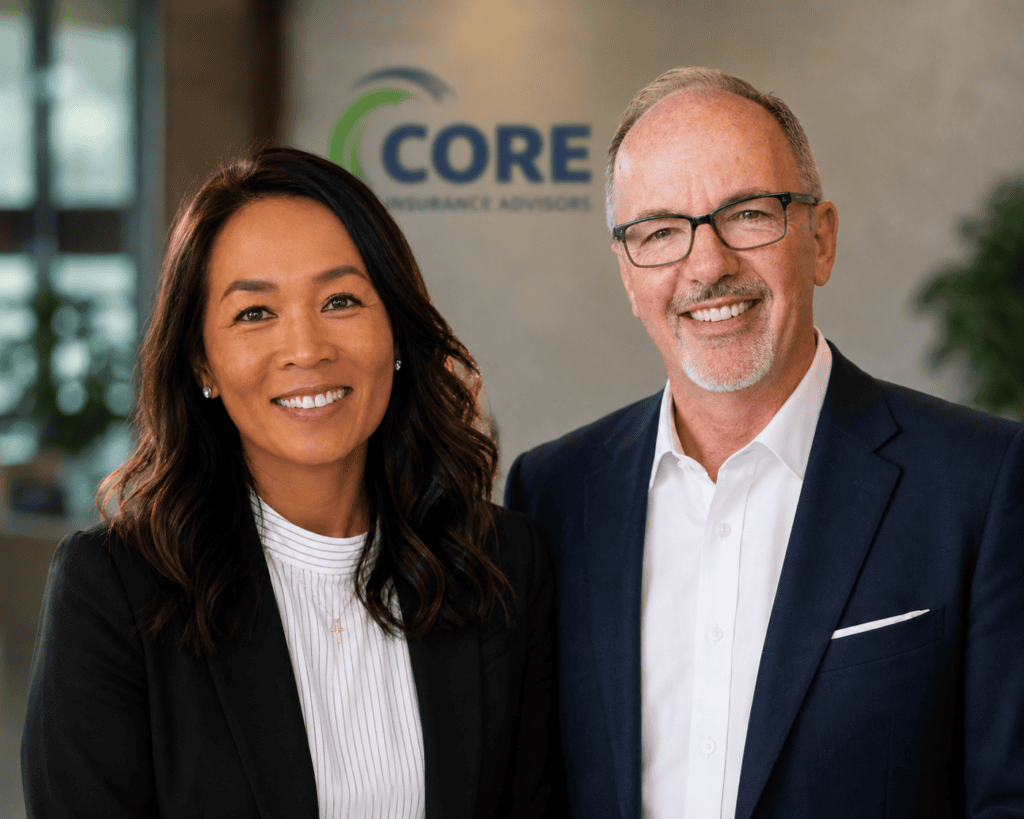 Two smiling business professionals standing in office